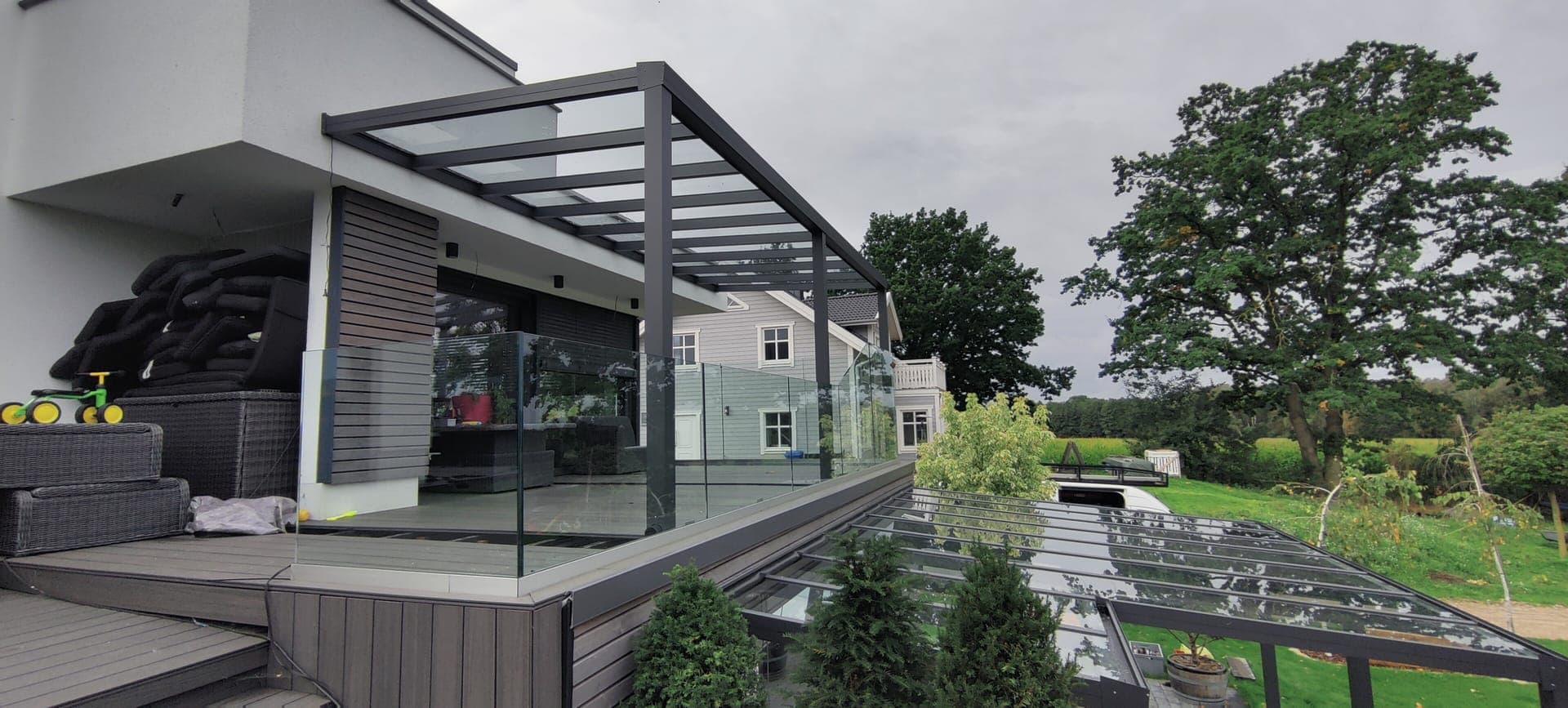 Hochwertige Terrassenüberdachung mit Glasdach und Sichtschutz